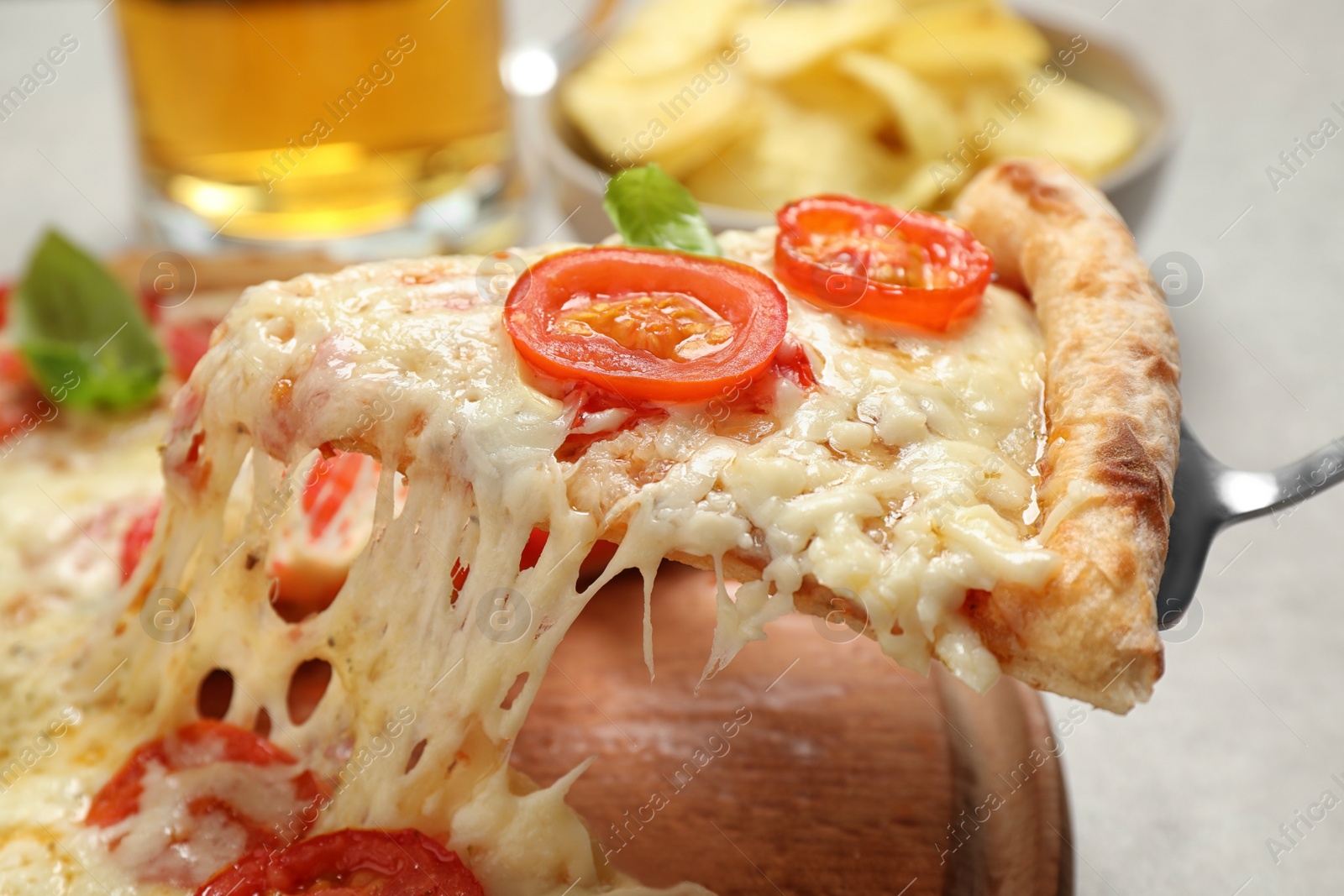 Photo of Taking slice of delicious pizza Margherita at table, closeup