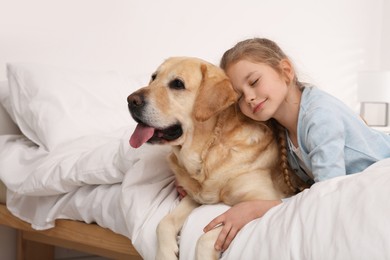 Photo of Young girl with her adorable dog on bed at home. Space for text