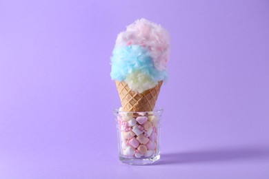 Photo of Sweet cotton candy in waffle cone on purple background