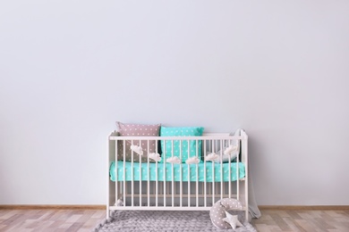 Baby room interior with crib near wall