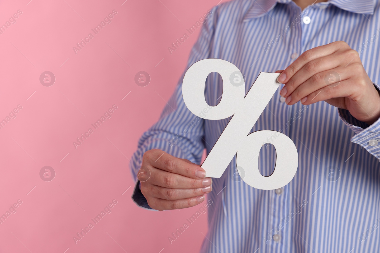 Photo of Woman holding percent sign on pink background, closeup. Space for text