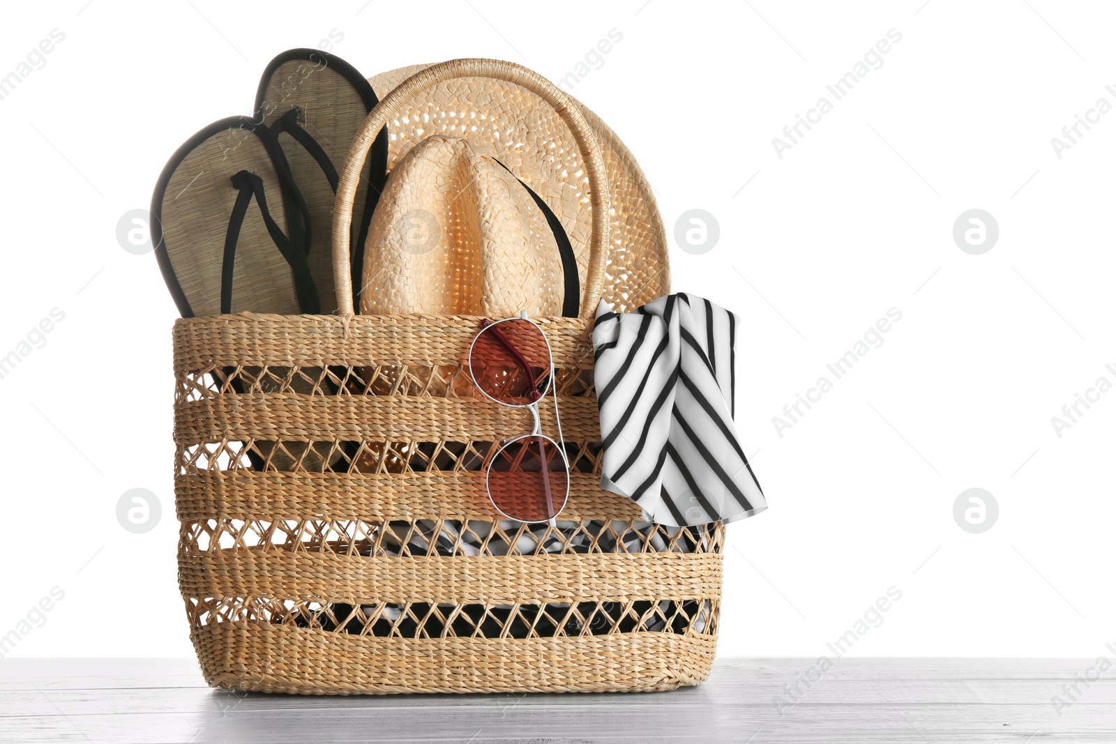 Photo of Set of beach accessories on wooden table, white background