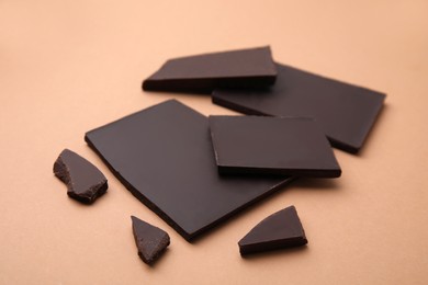Photo of Broken tasty chocolate bar on brown background