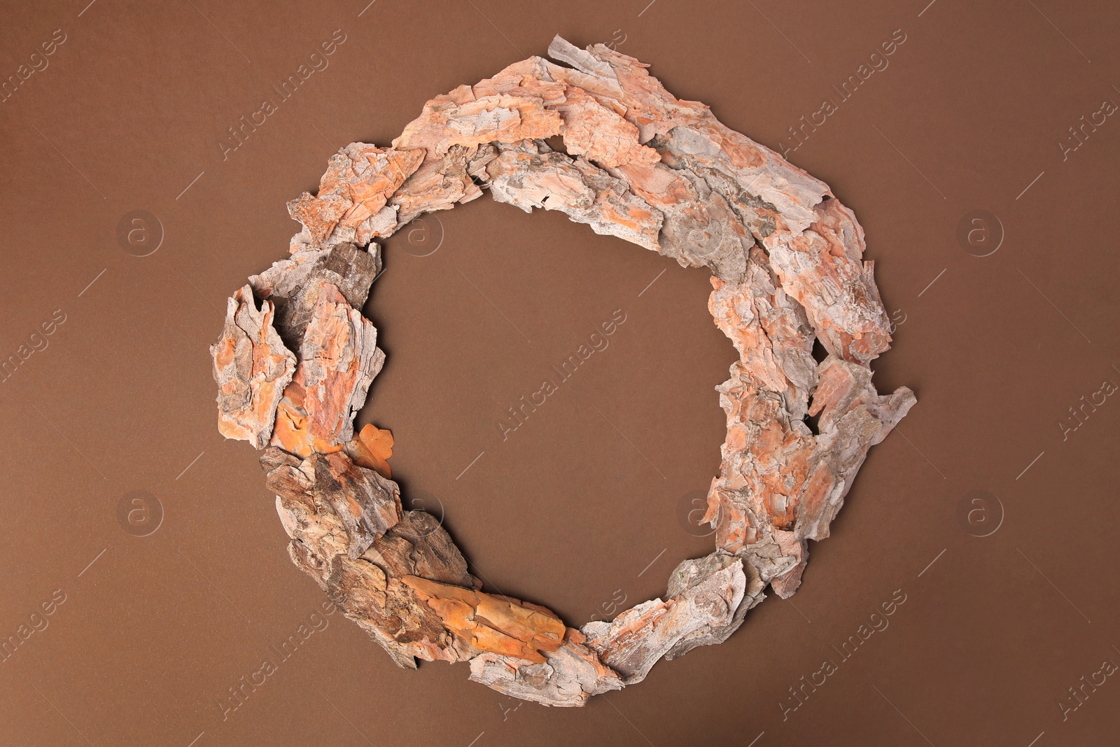 Photo of Frame made of tree bark pieces on brown background, flat lay. Space for text
