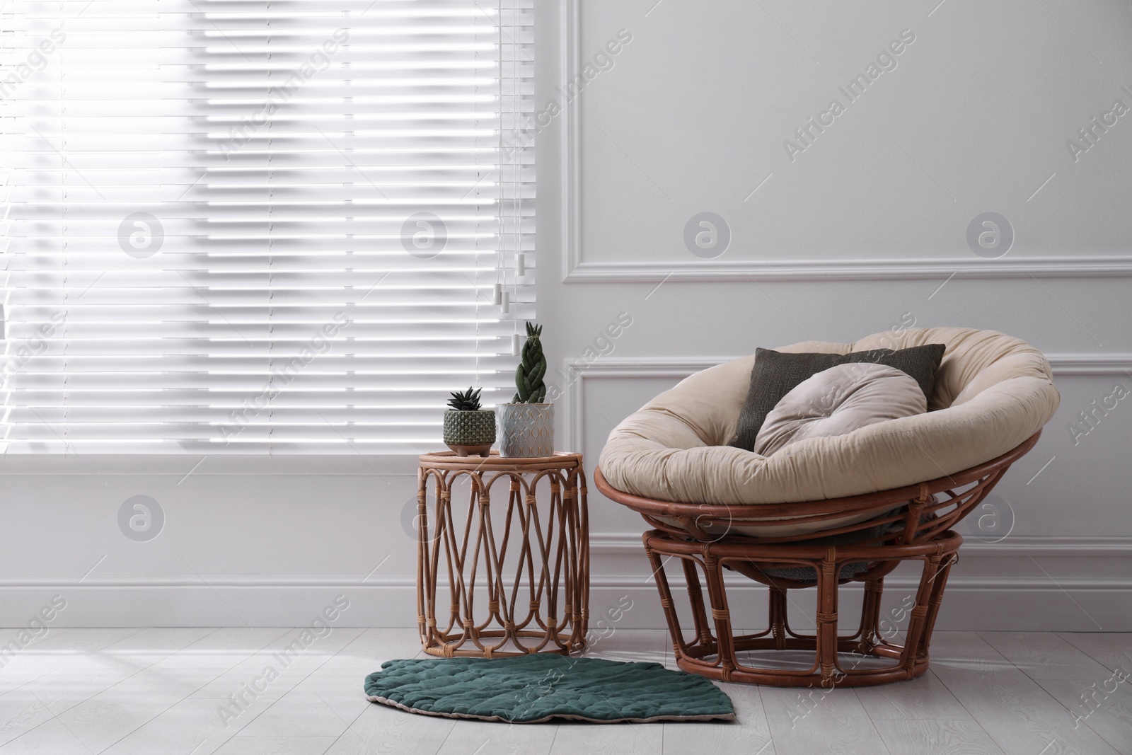 Photo of Comfortable papasan chair and beautiful plants near window indoors