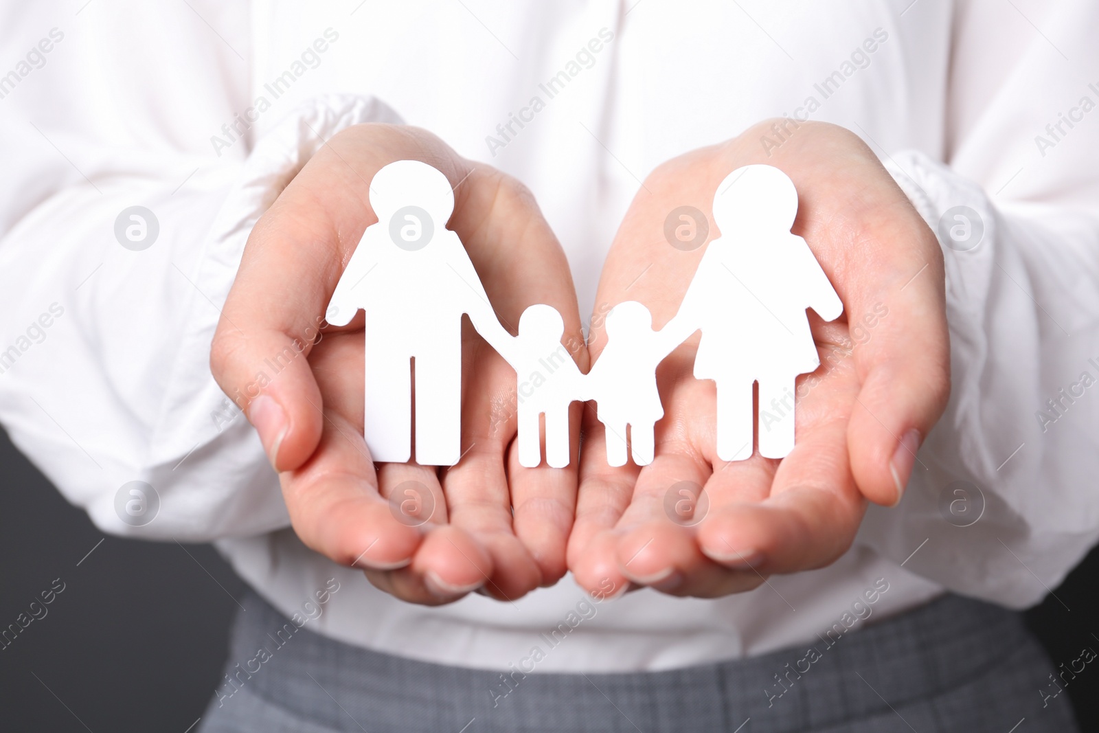 Photo of Woman holding cutout paper family, closeup. Life insurance concept