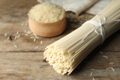 Raw rice noodles on wooden table, closeup