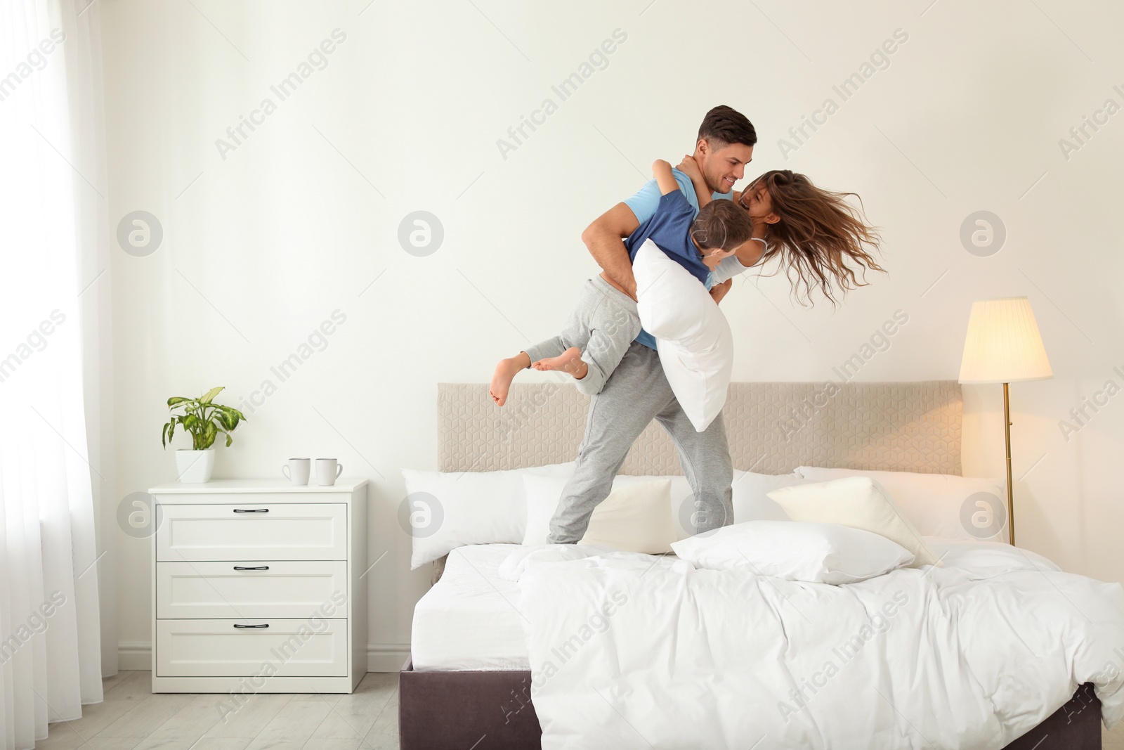 Photo of Happy father playing with his children in bedroom