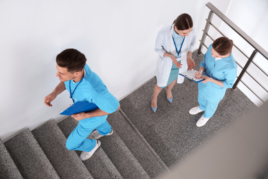 Photo of Team of professional doctors on staircase in clinic