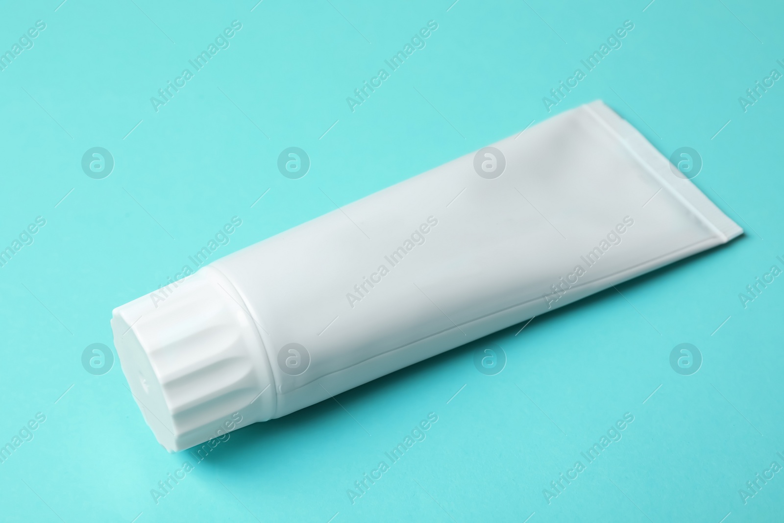 Photo of Blank tube of toothpaste on color background