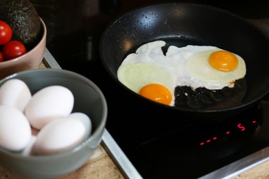 Photo of Frying eggs in kitchen for tasty breakfast