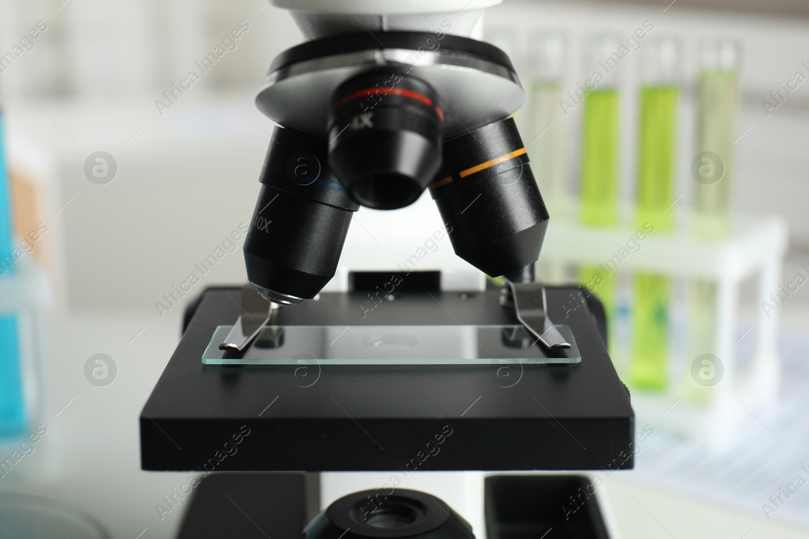 Photo of Modern microscope with different lenses in laboratory, closeup. Medical equipment