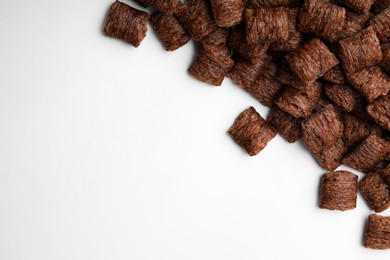 Photo of Chocolate cereal pads on white background, flat lay. Space for text