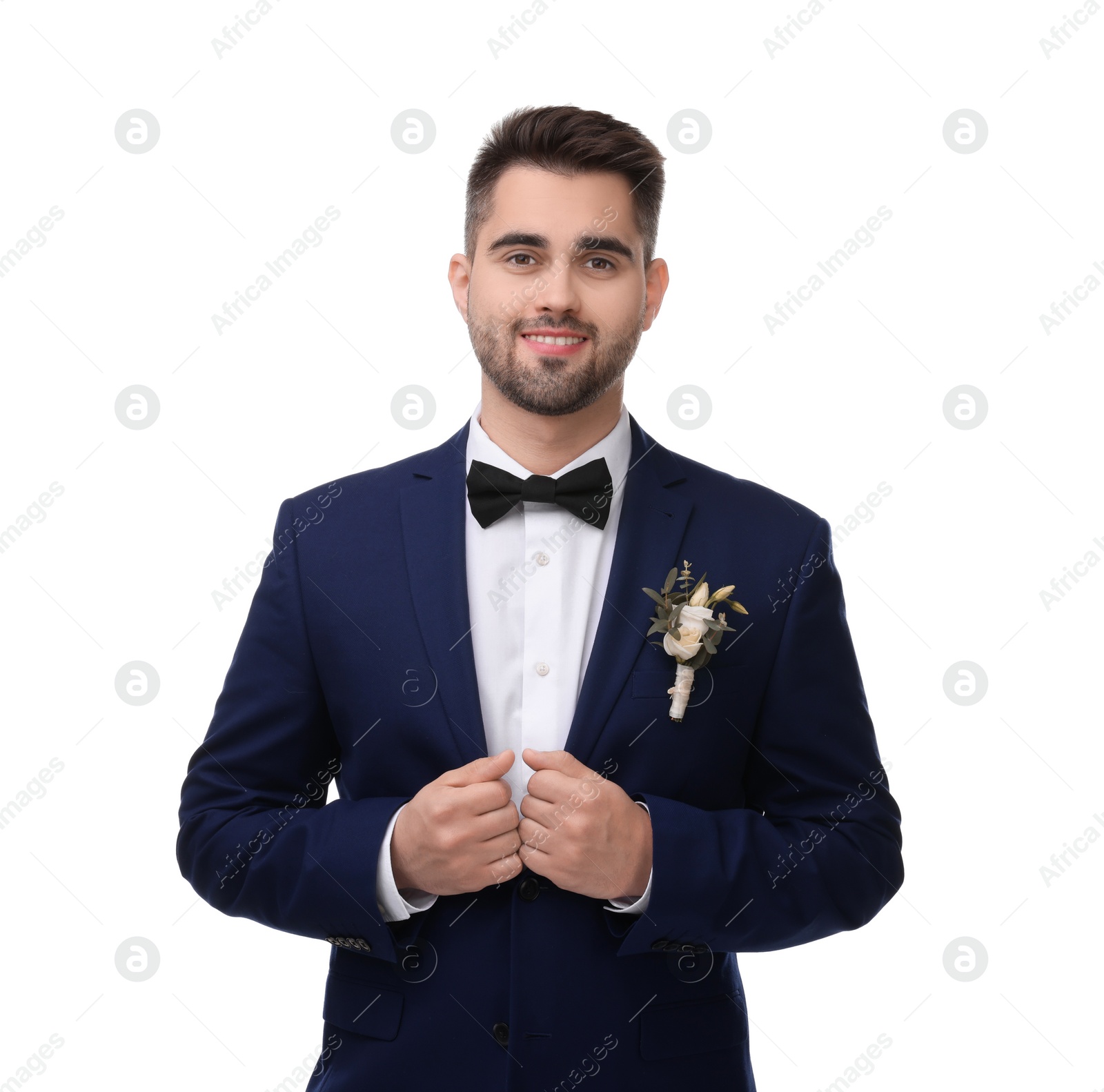 Photo of Handsome young groom with boutonniere on white background. Wedding accessory