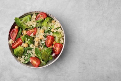 Photo of Healthy meal. Tasty salad with quinoa, chickpeas and vegetables on grey table, top view with space for text