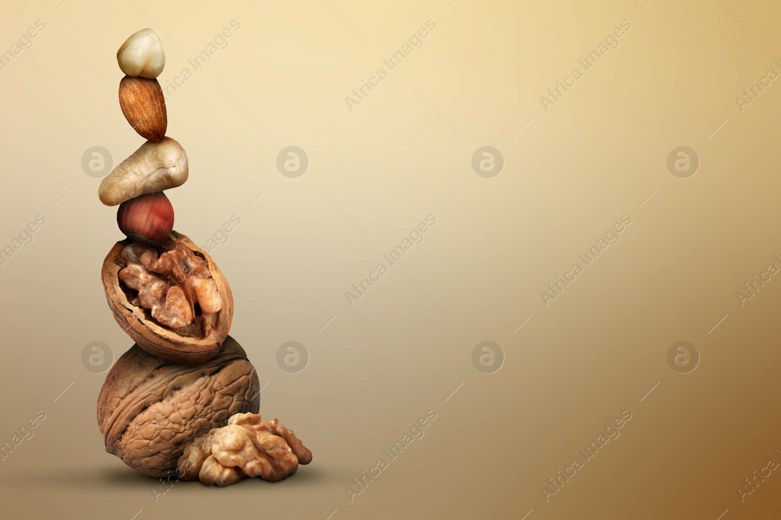 Image of Stacked different nuts on light brown gradient background, space for text