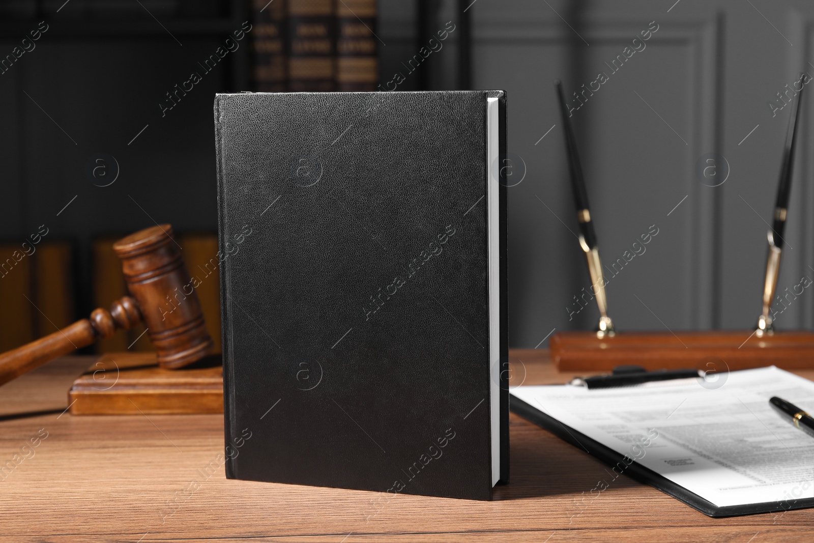Photo of Tax law. Book, form and gavel on wooden table