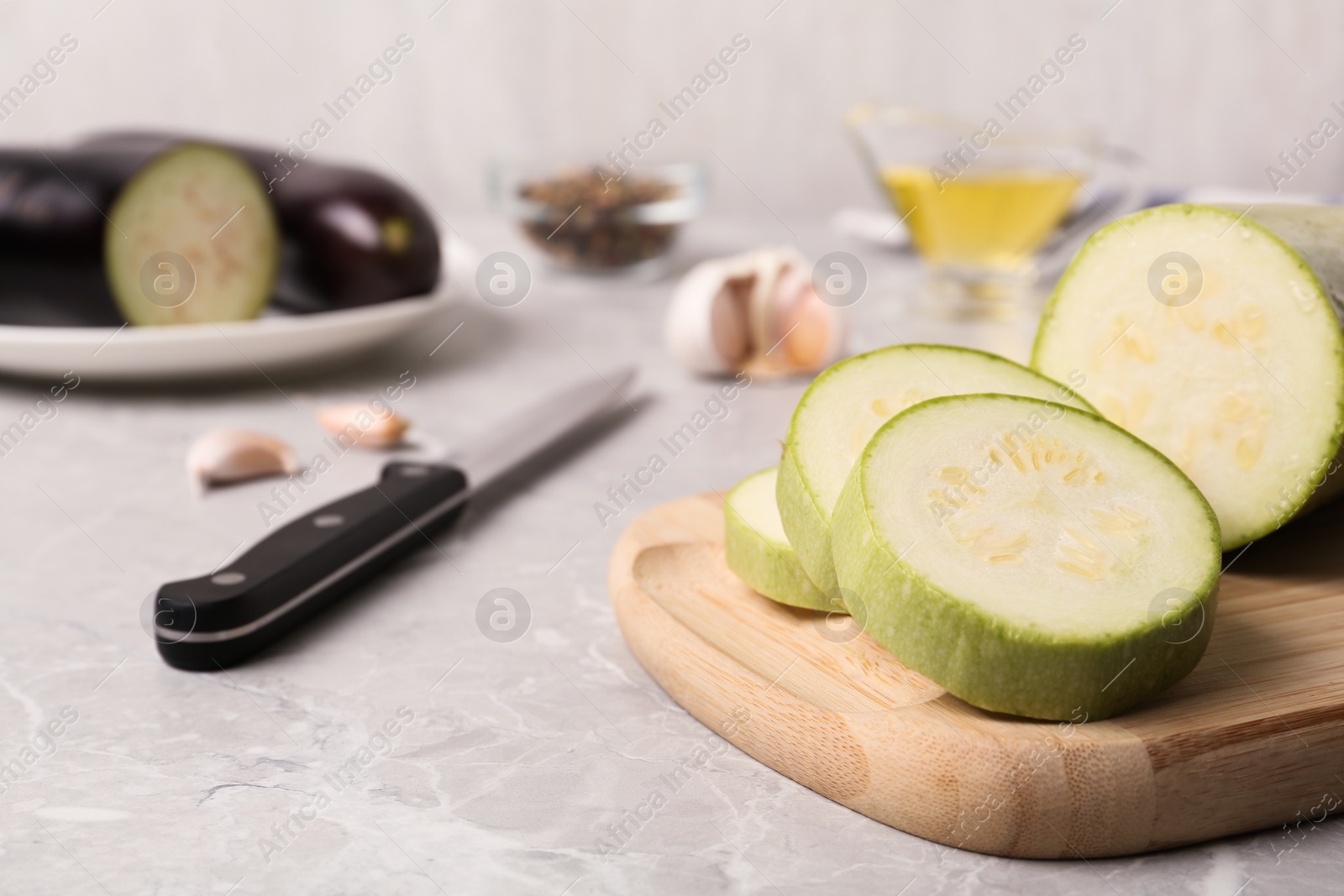 Photo of Slices of fresh zucchini on marble table, closeup. Space for text