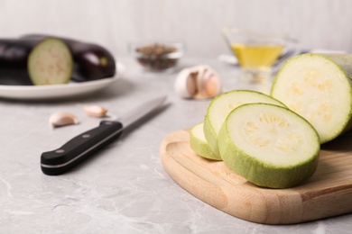 Photo of Slices of fresh zucchini on marble table, closeup. Space for text