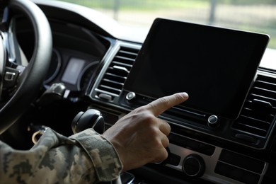 Photo of Soldier using tablet in car, closeup view