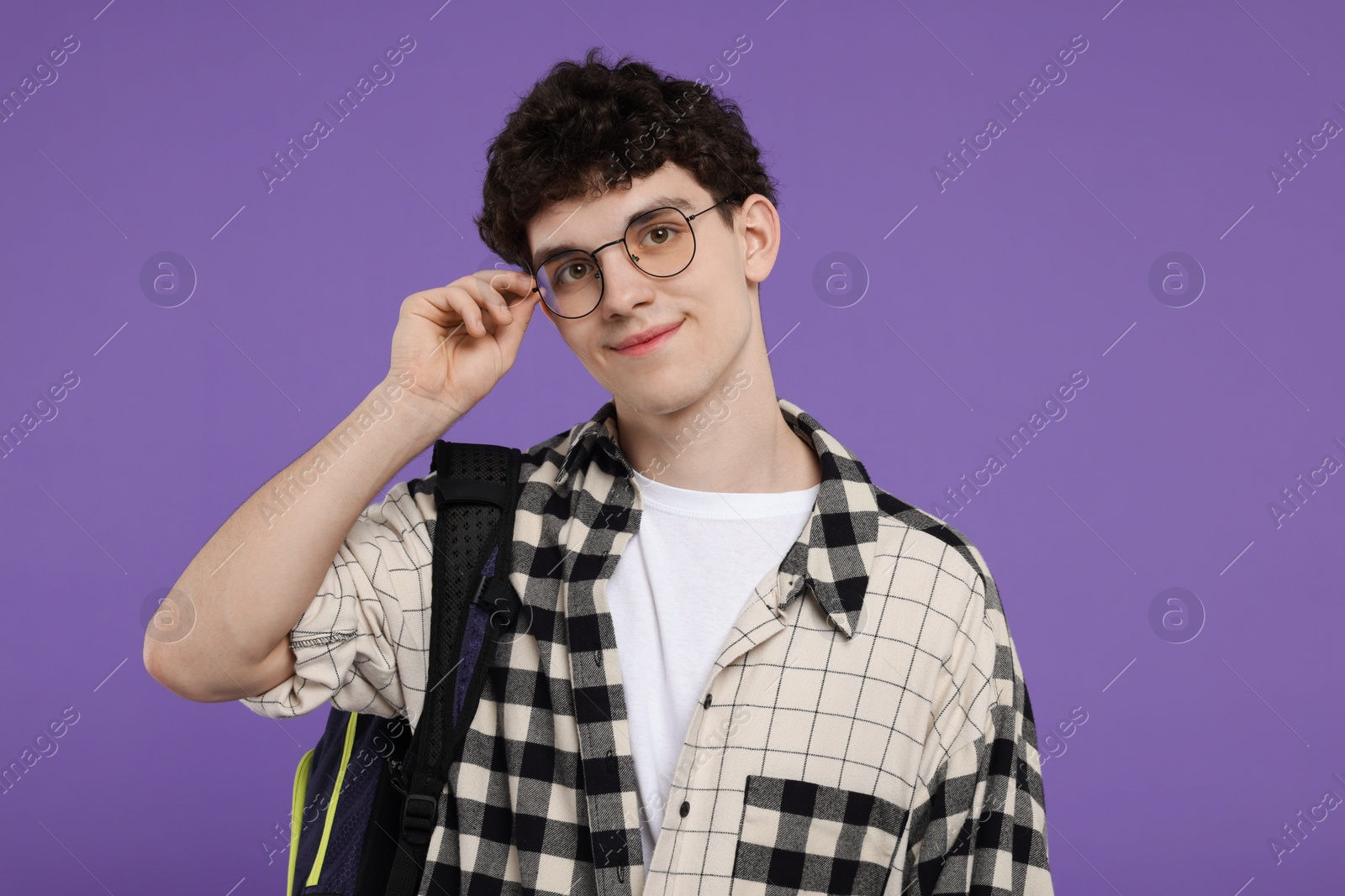 Photo of Portrait of student with backpack on purple background