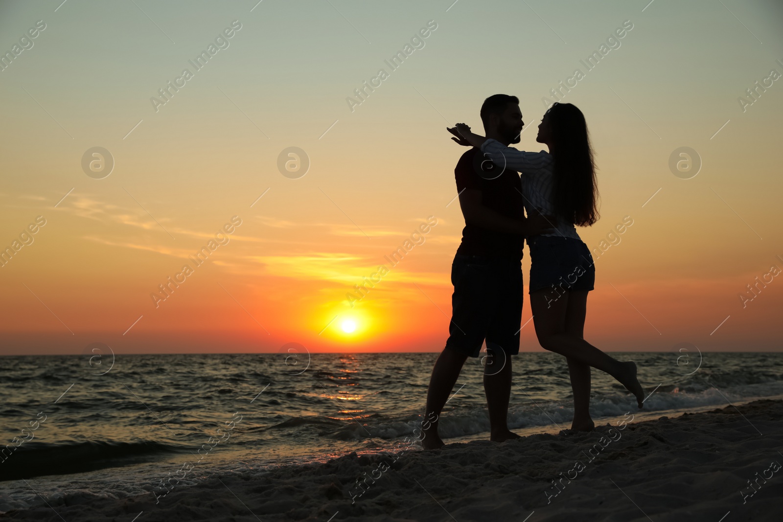 Photo of Couple spending time together on beach at sunset