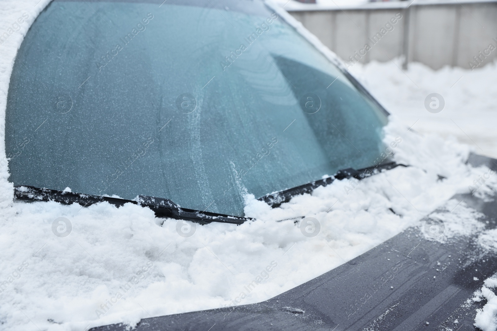 Photo of Car windshield with wiper blades cleaned from snow outdoors on winter day