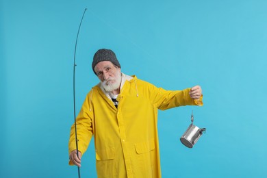Photo of Fisherman with fishing rod and tin can on light blue background