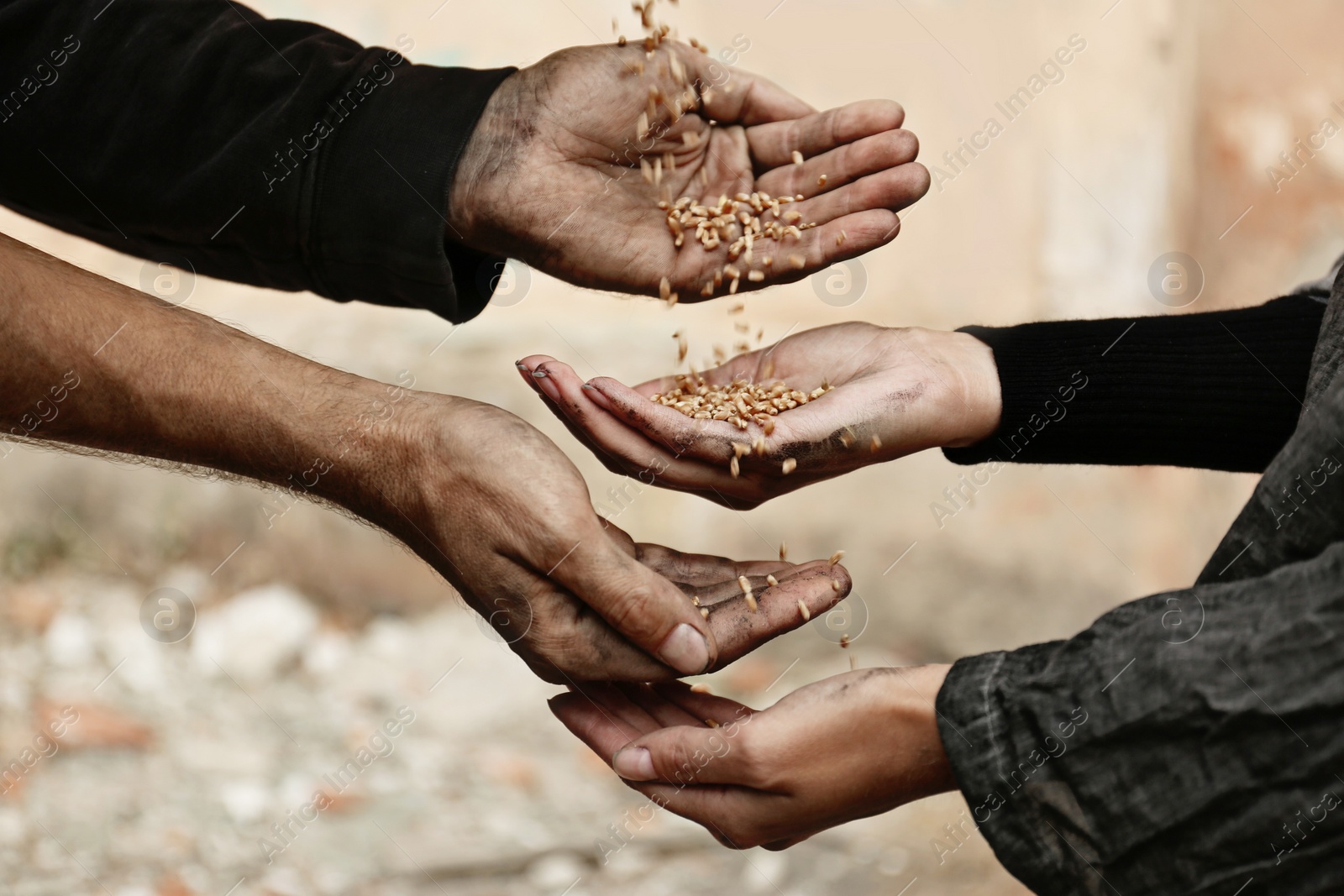 Photo of Poor homeless people sharing food outdoors, closeup