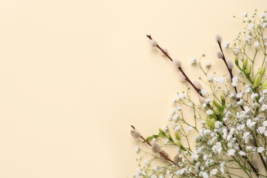 Photo of Beautiful gypsophila, freesia and pussy willow branches on beige background, flat lay. Space for text