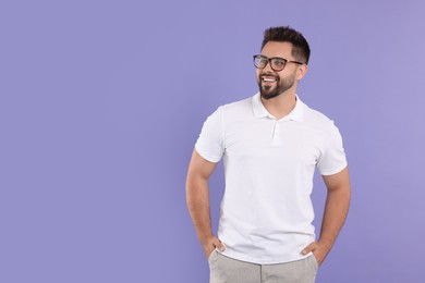Handsome man wearing glasses on violet background, space for text