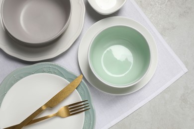 Photo of Beautiful ceramic dishware and cutlery on light grey table, top view