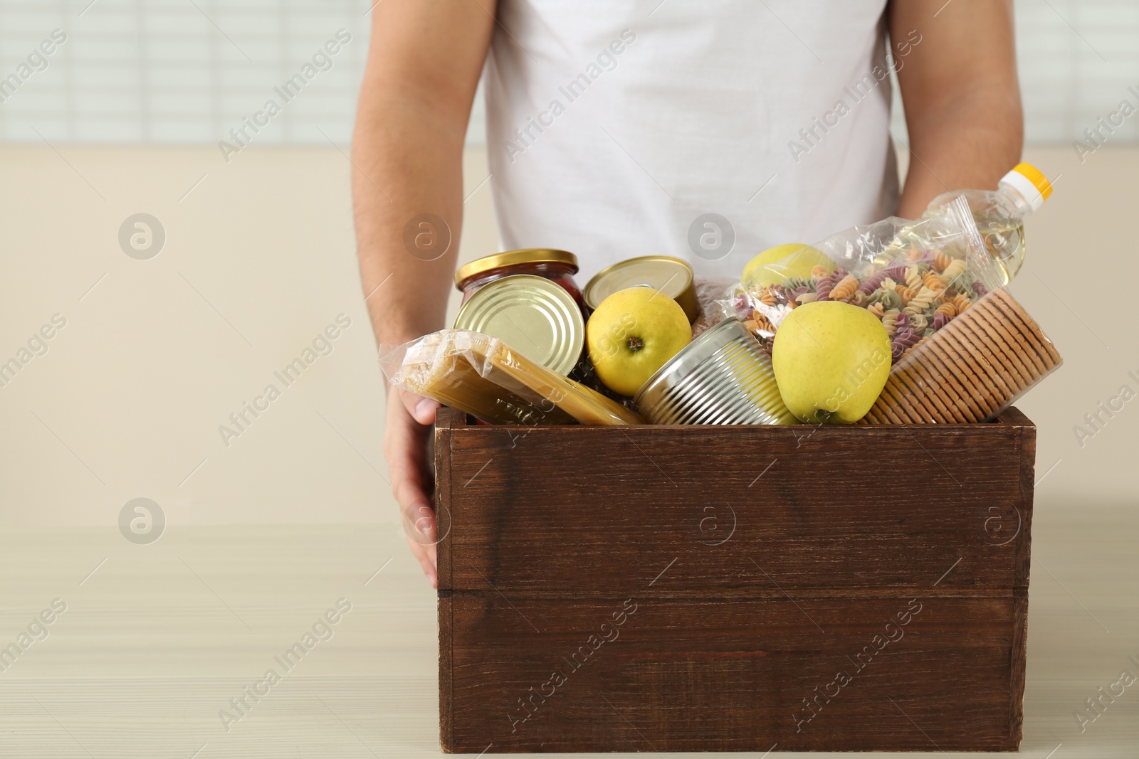 Photo of Man holding donation box with food, closeup