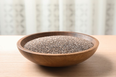 Photo of Bowl with chia seeds on table against blurred background