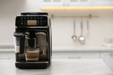 Modern coffee machine with glass cup of latte on white marble countertop in kitchen