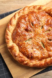 Tasty homemade pie with filling on wooden table, top view