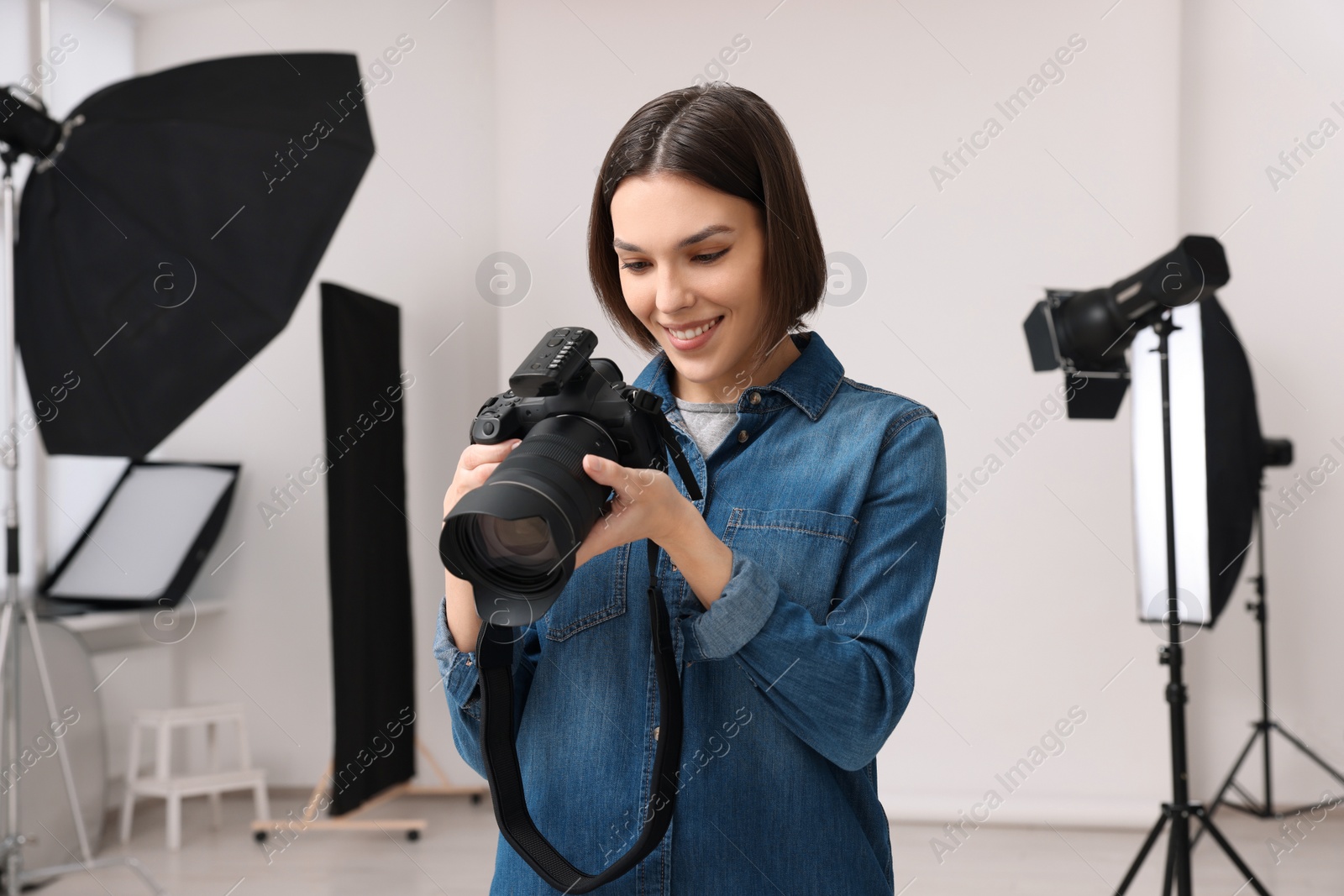 Photo of Professional photographer with camera in modern photo studio