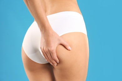 Photo of Closeup view of slim woman in underwear on color background. Cellulite problem concept