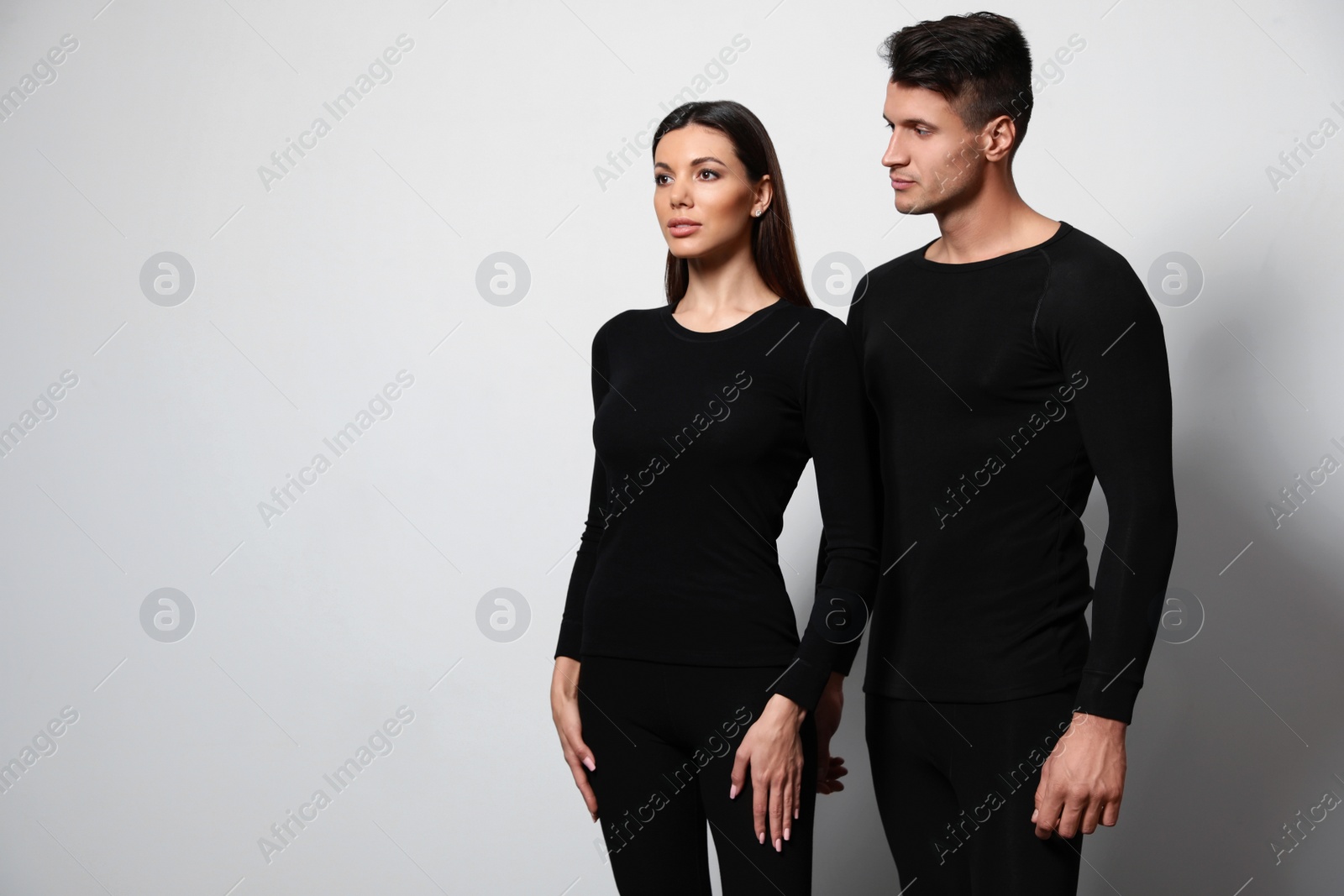 Photo of Couple wearing thermal underwear on light grey background. Space for text