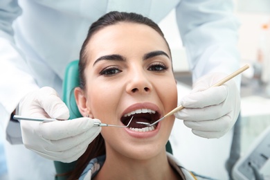 Photo of Professional dentist working with patient in modern clinic