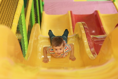 Cute little child playing at indoor amusement park