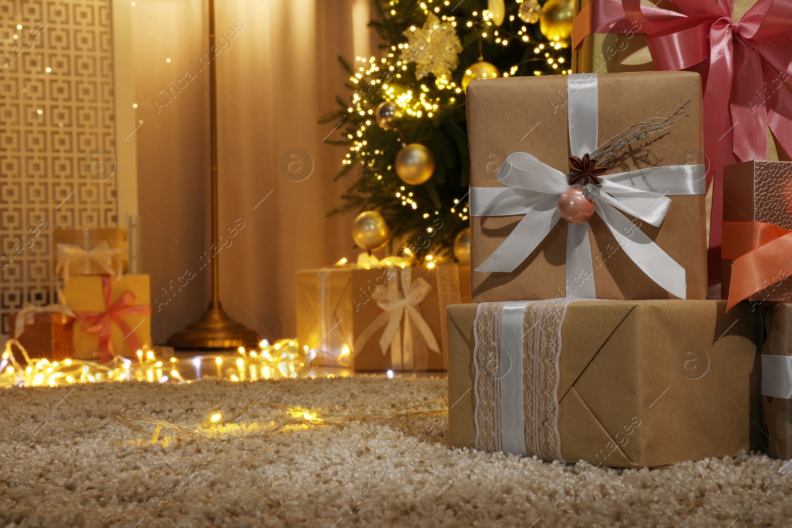 Photo of Many gift boxes under decorated Christmas tree at home. Space for text