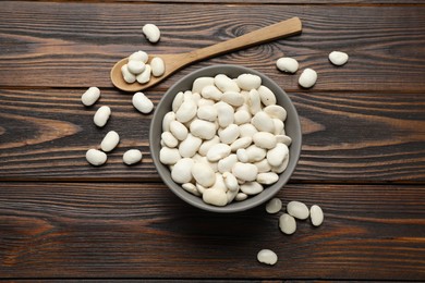 Raw white beans on wooden table, flat lay