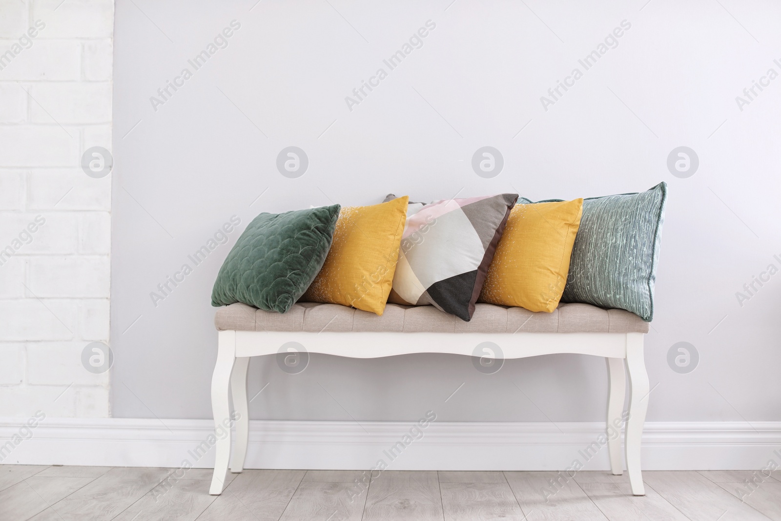 Photo of Different pillows on couch near light wall in room