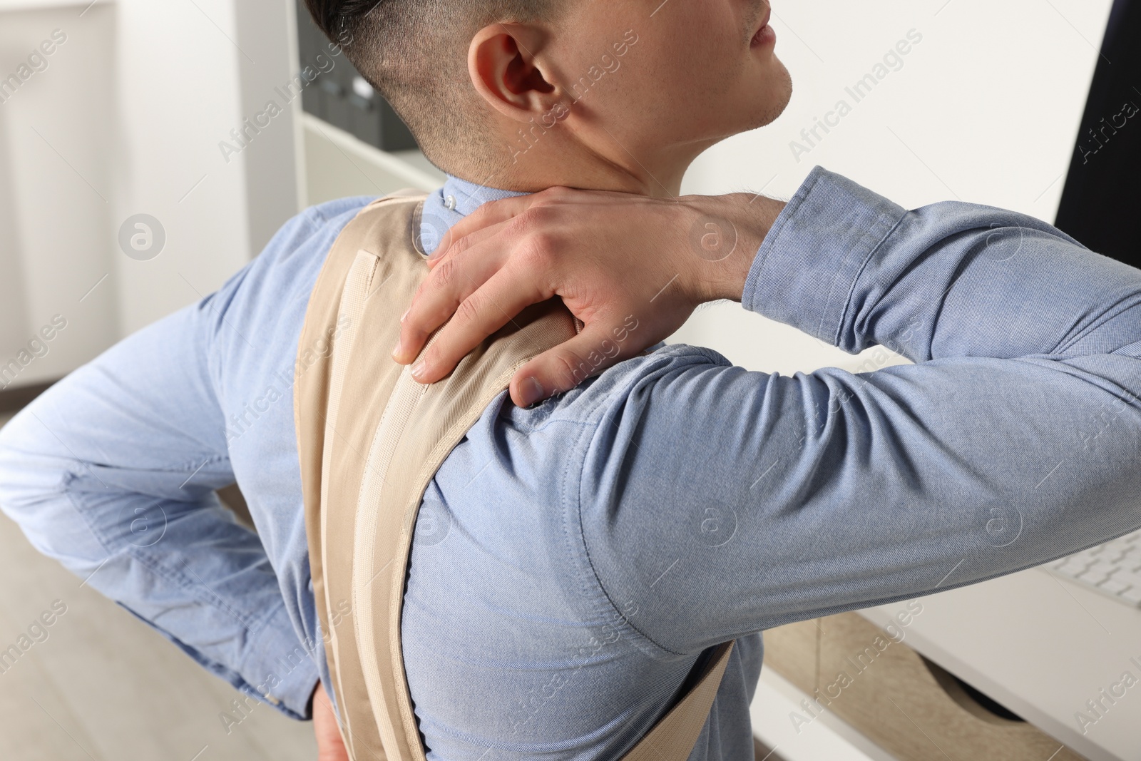 Photo of Man with orthopedic corset in room, closeup