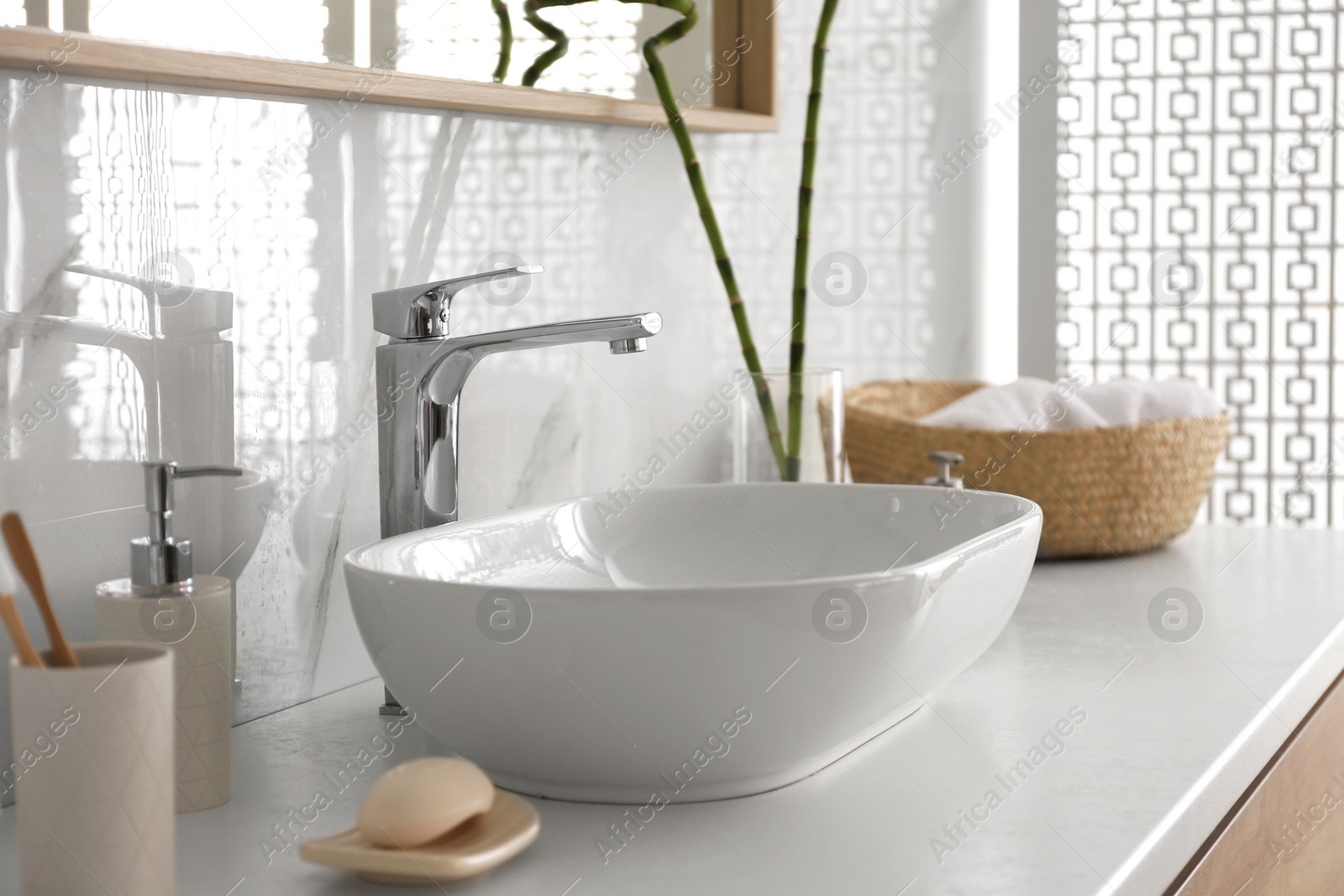 Photo of Stylish vessel sink under mirror in bathroom. Interior element