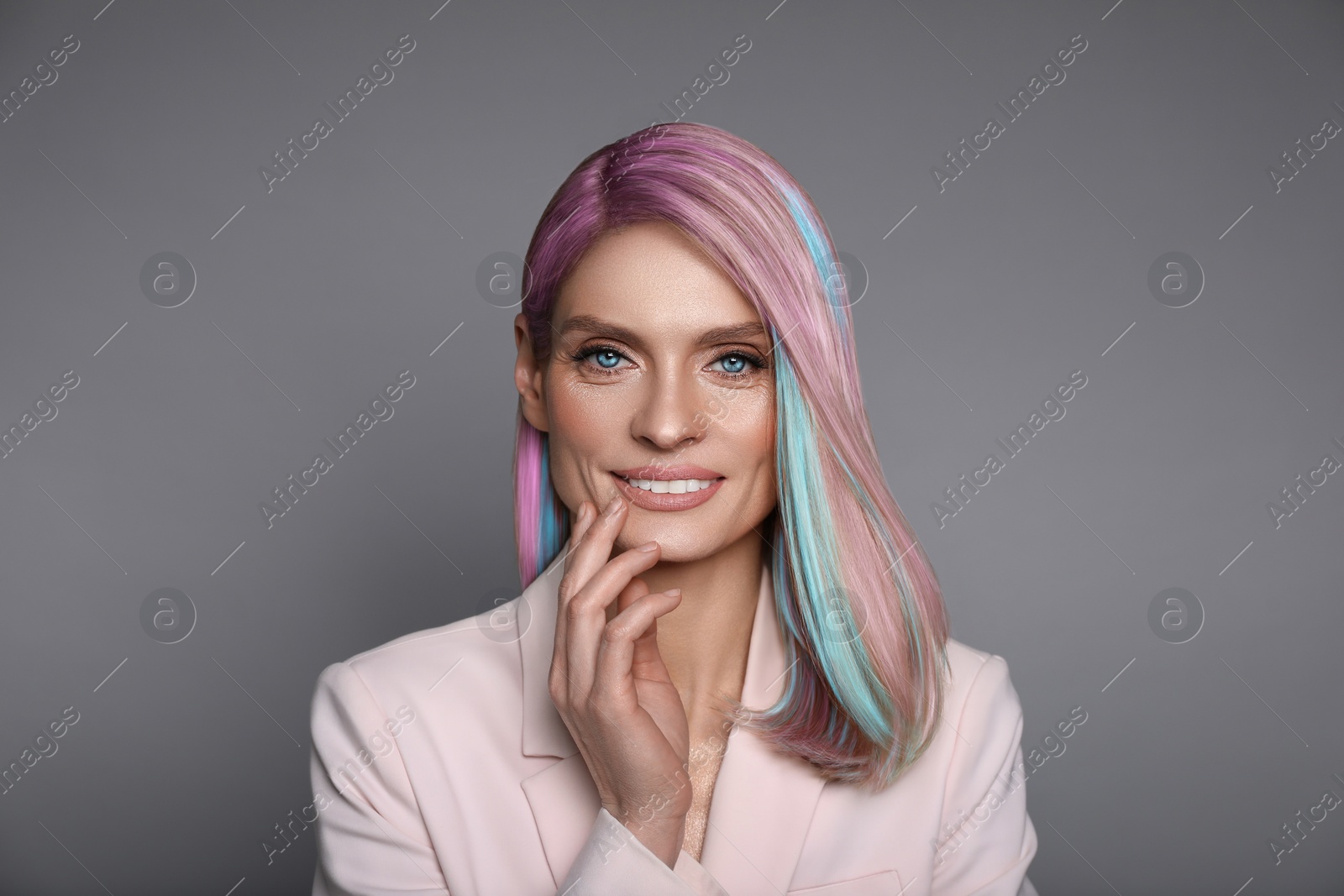 Image of Hair styling. Attractive woman with colorful hair on grey background