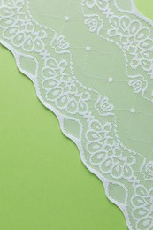 White lace on green background, top view