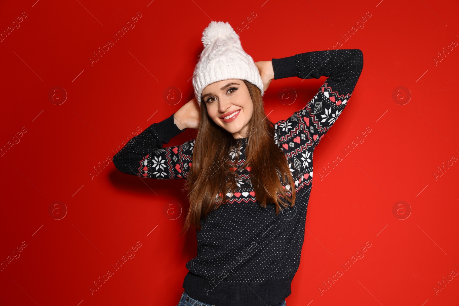 Photo of Young woman wearing Christmas sweater on red background