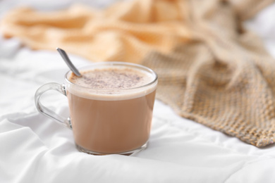 Cup of morning coffee on bed indoors